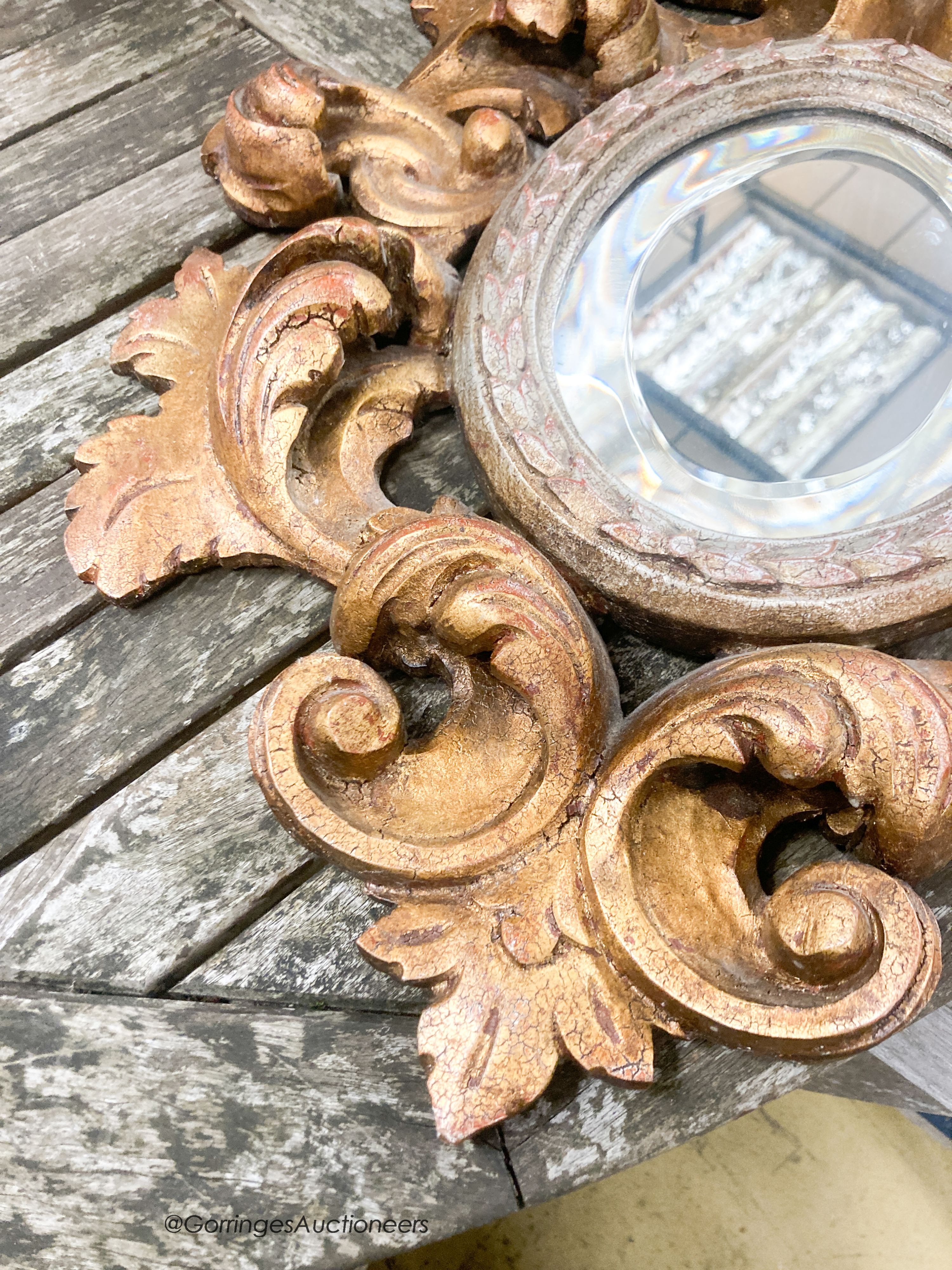 A 1930's Italian carved giltwood oval mirror, width 47cm, height 59cm